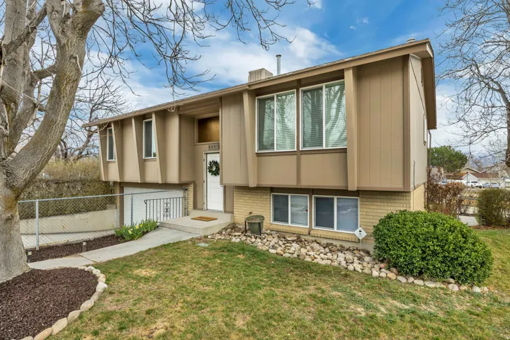 Bi-level home with brick siding, a chimney, and an attached garage