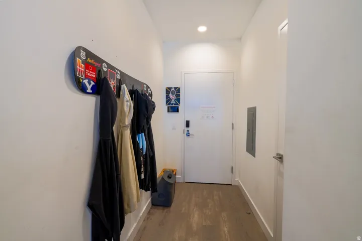 Doorway with wood finished floors, recessed lighting, and electric panel