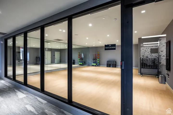 Doorway with wood finished floors and recessed lighting