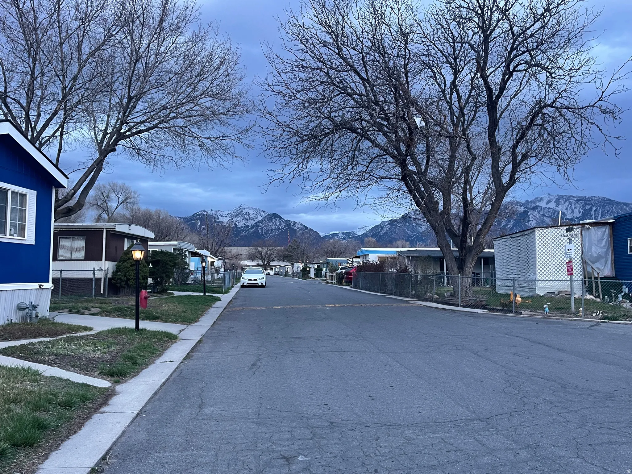 View of asphalt road with a mountain view, a residential view, and curbs