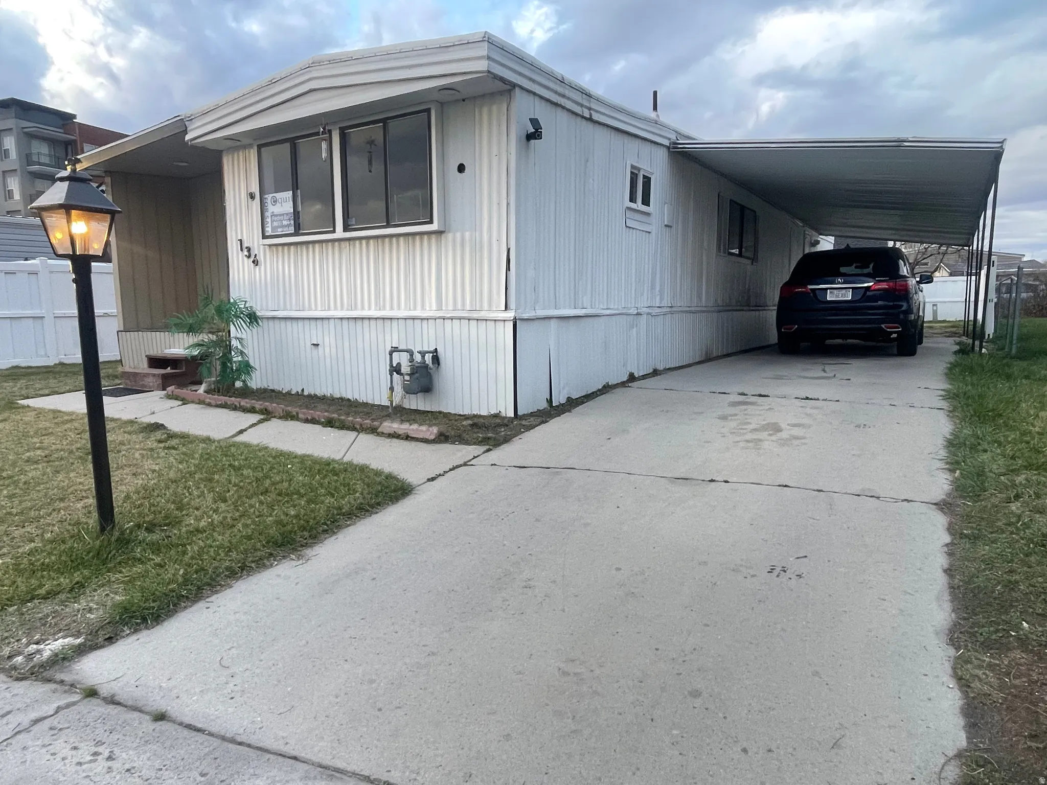 View of front of home featuring concrete driveway and an attached carport