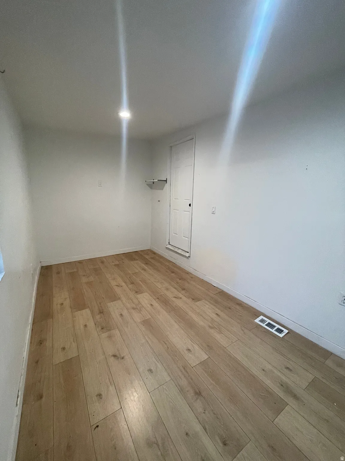 Finished basement featuring light wood finished floors and baseboards