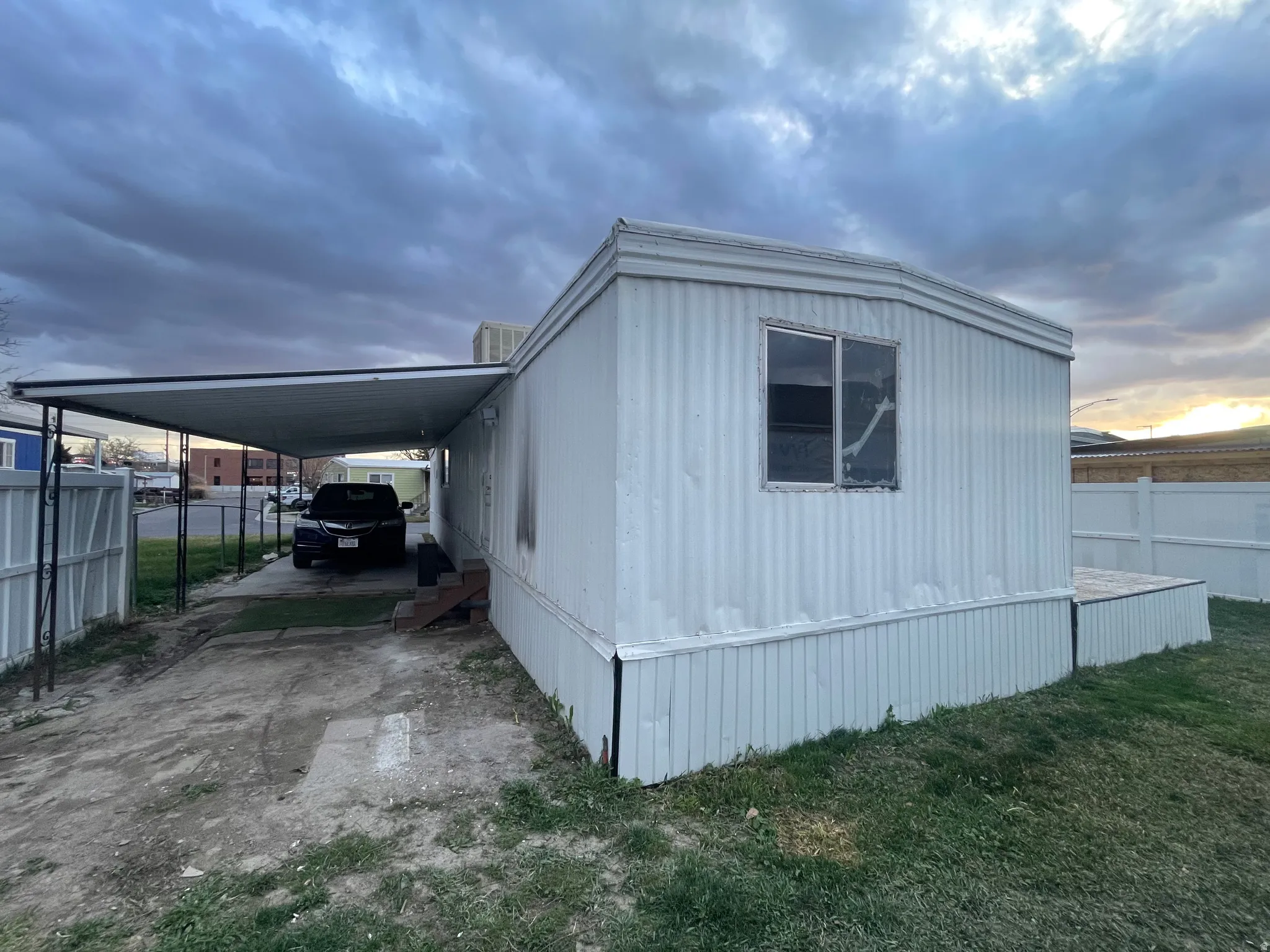 Property exterior at dusk featuring an attached carport