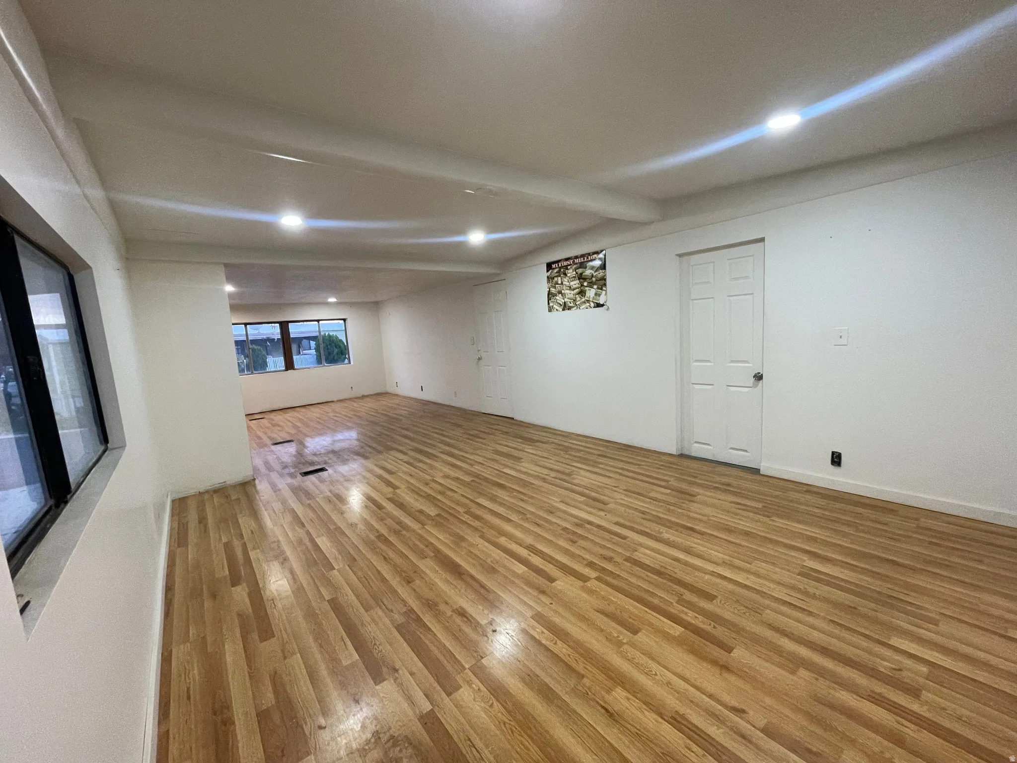 Unfurnished living room featuring recessed lighting, light wood-style flooring, and beamed ceiling