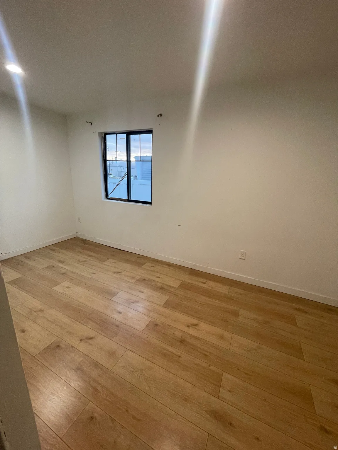 Spare room featuring light wood finished floors and baseboards