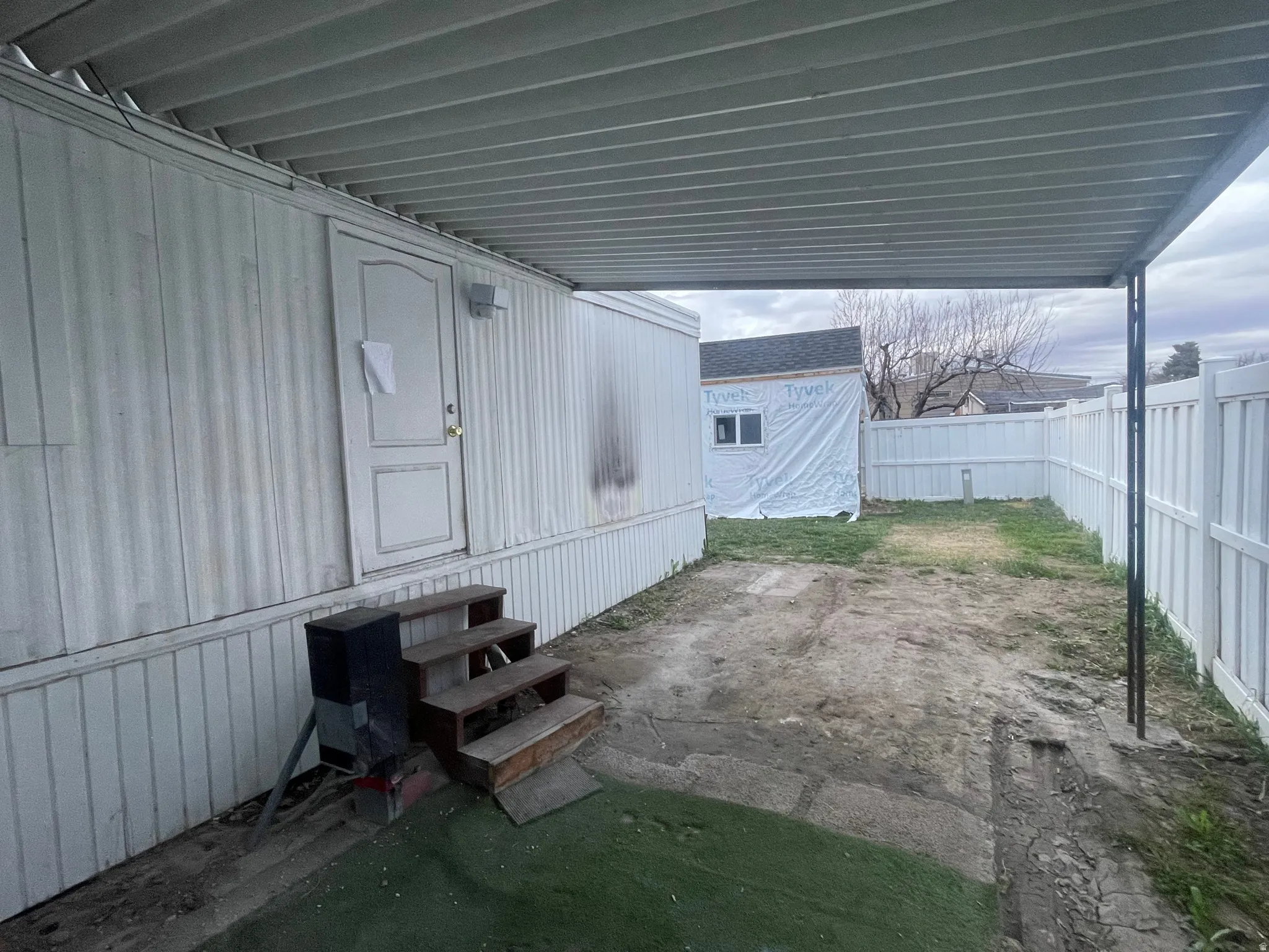 Fenced backyard with entry steps and a patio