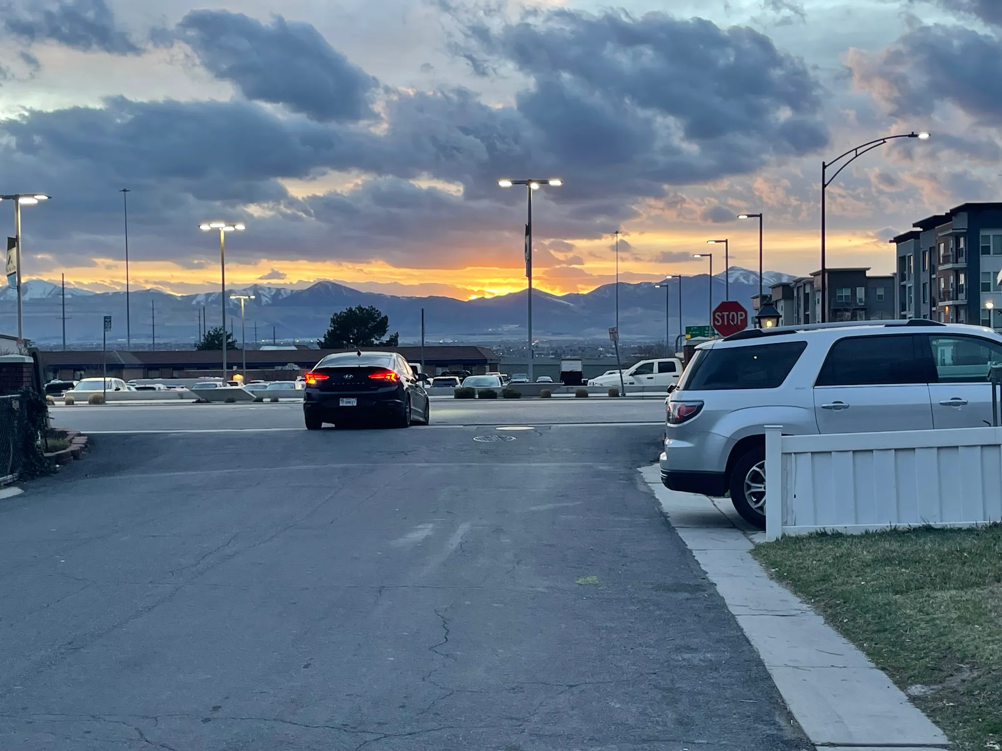 View of asphalt street featuring a mountain view, traffic signs, and street lighting