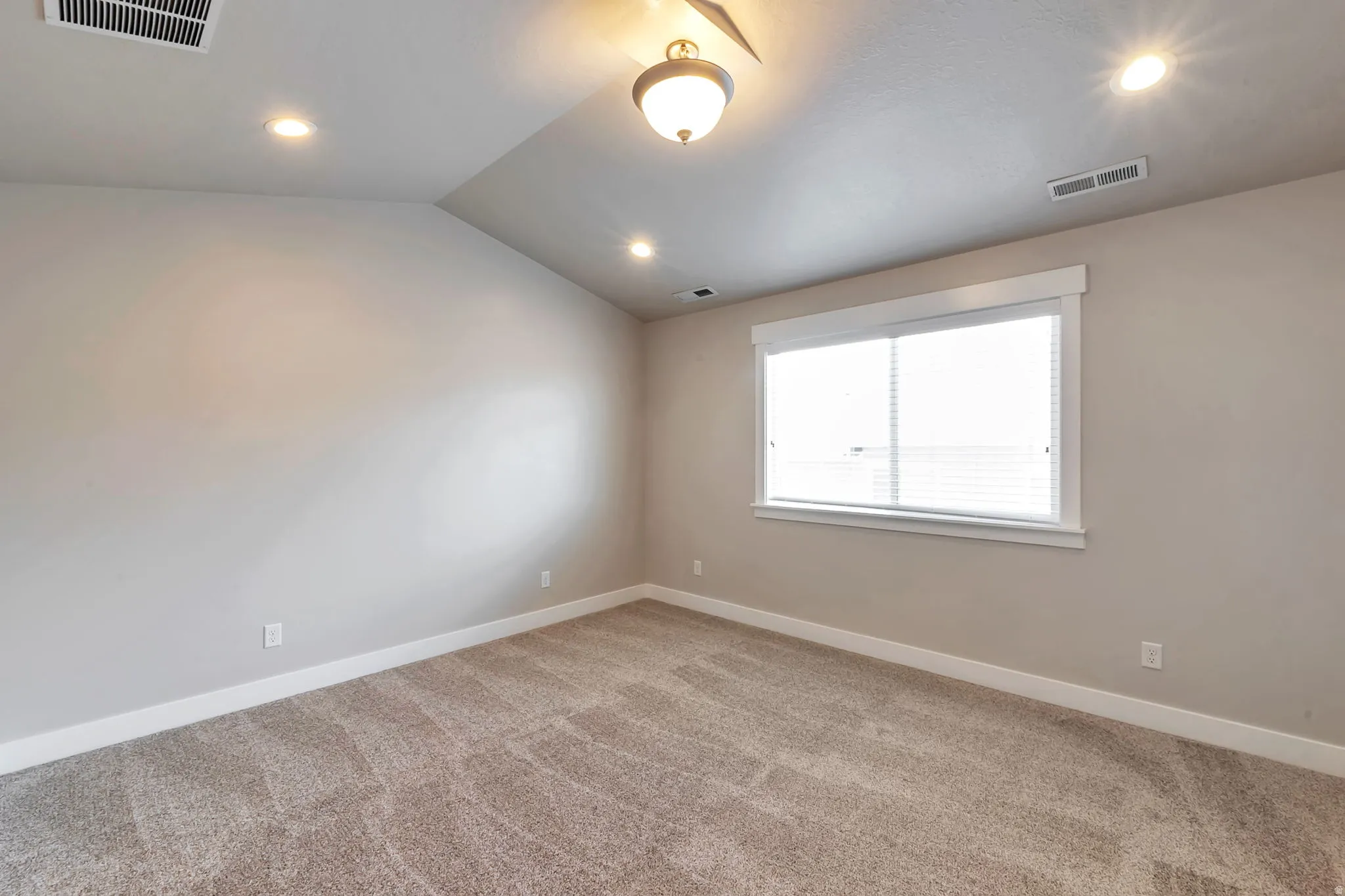 Primary bedroom with vaulted ceilings