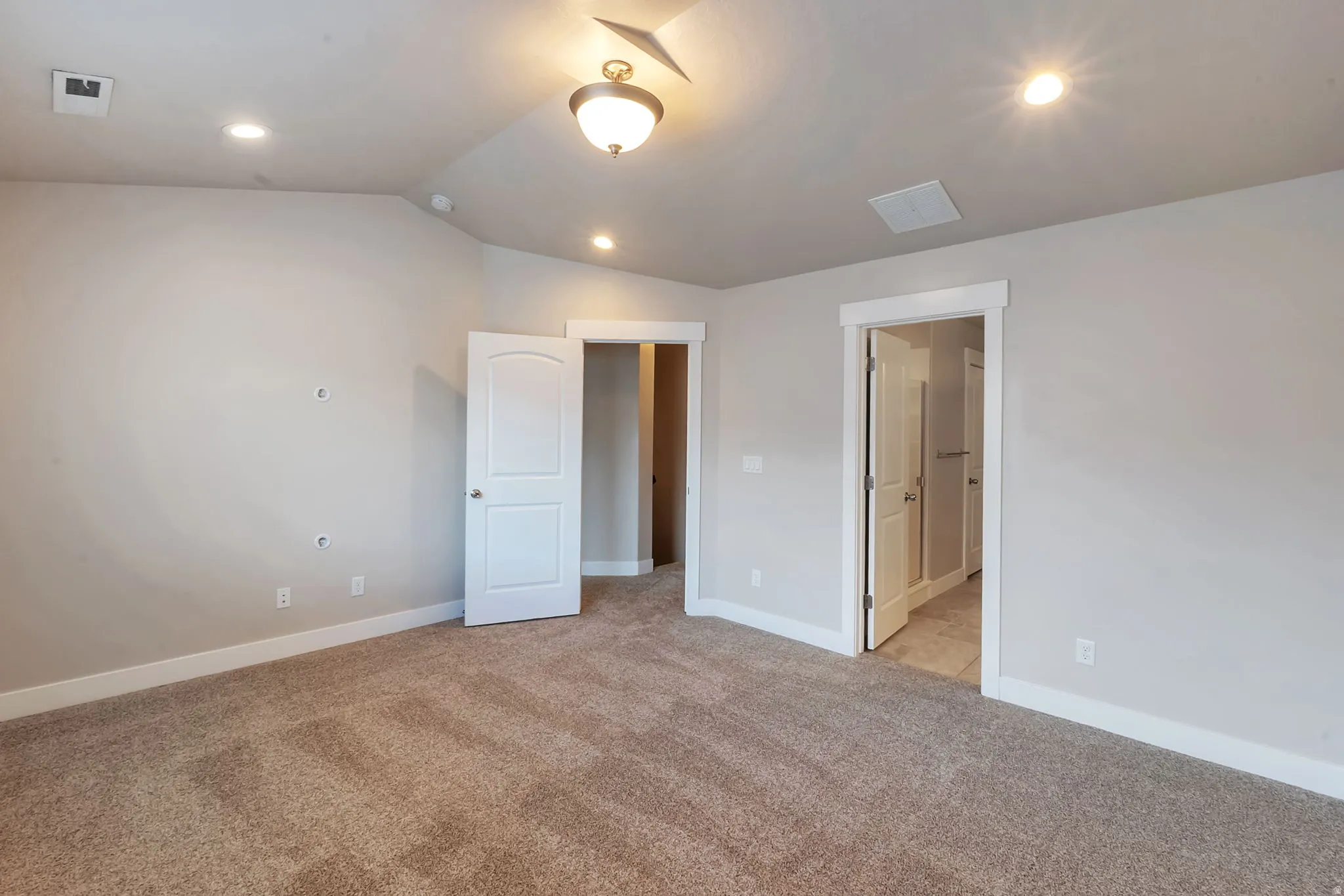 Primary bedroom with vaulted ceilings