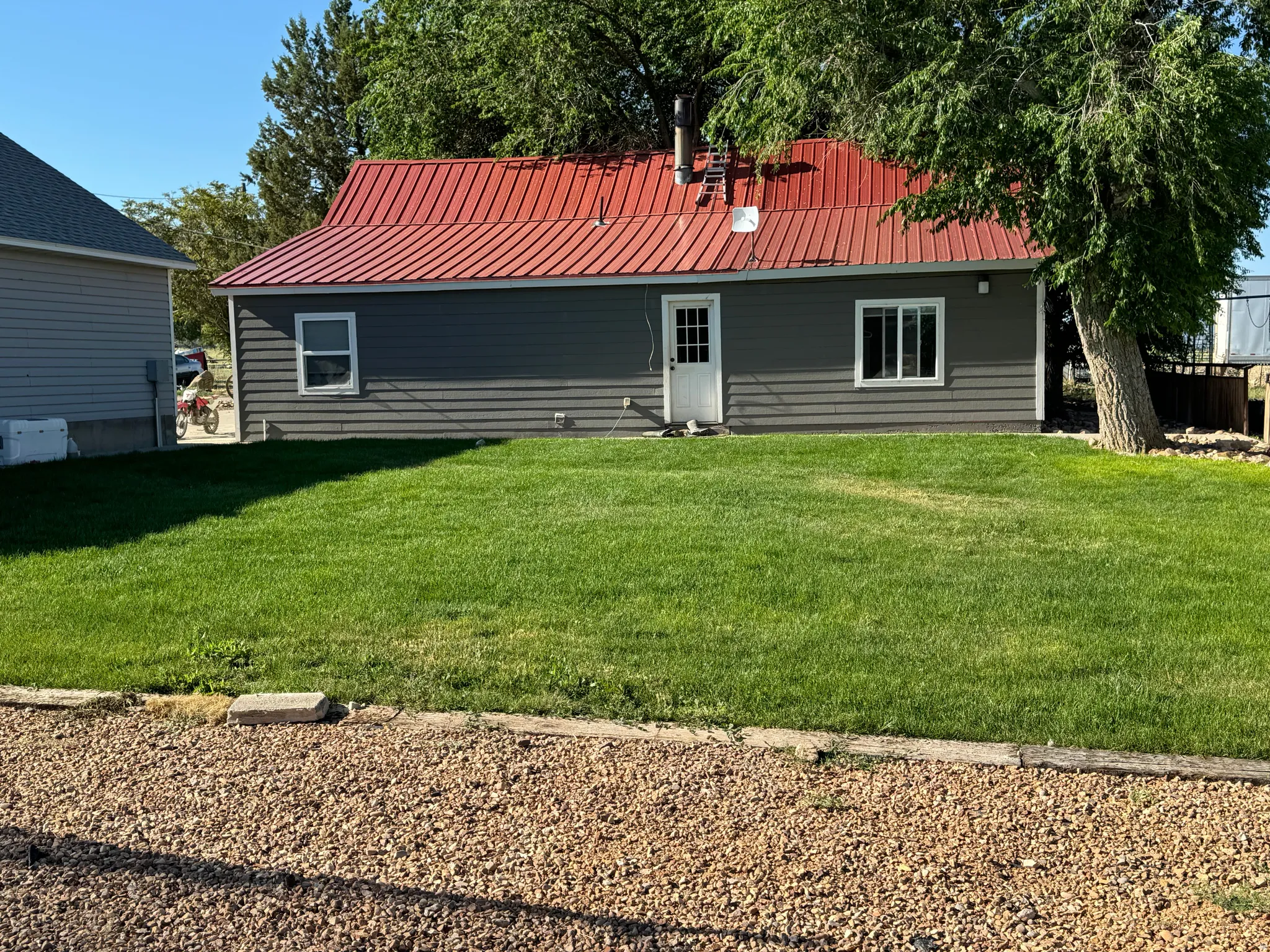 Rear view of property featuring a metal roof and a yard