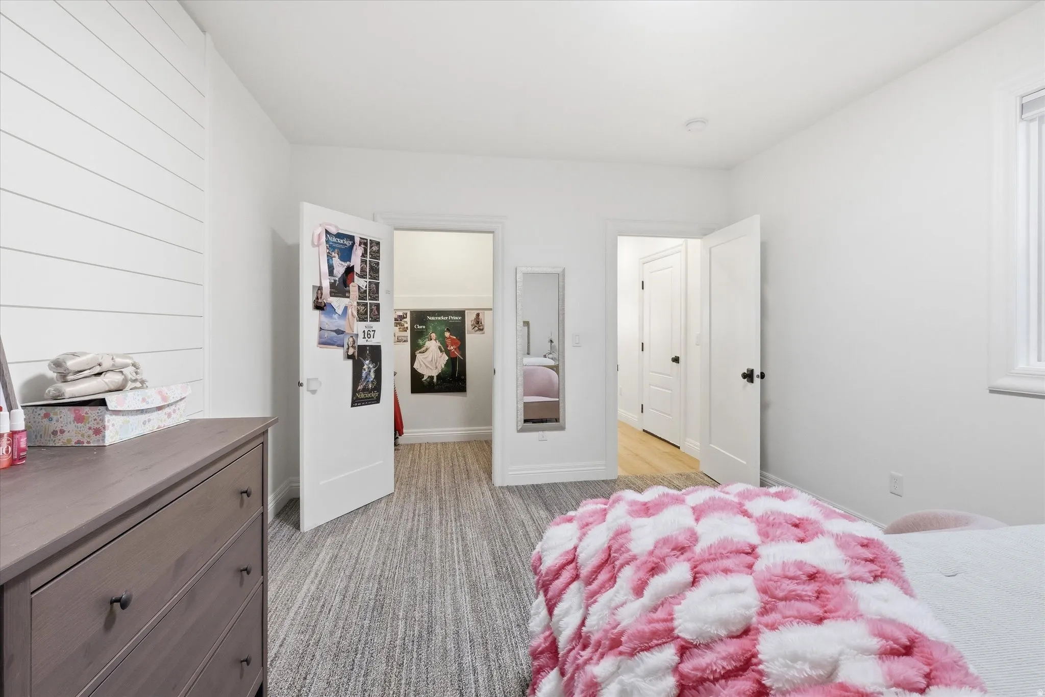 Bedroom with a spacious closet and light carpet