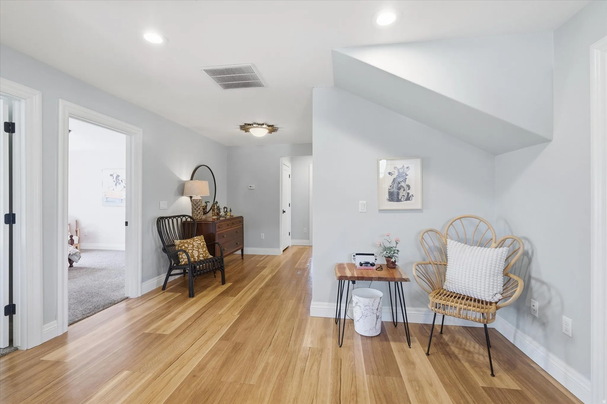 Sitting room with light wood-type flooring and recessed lighting