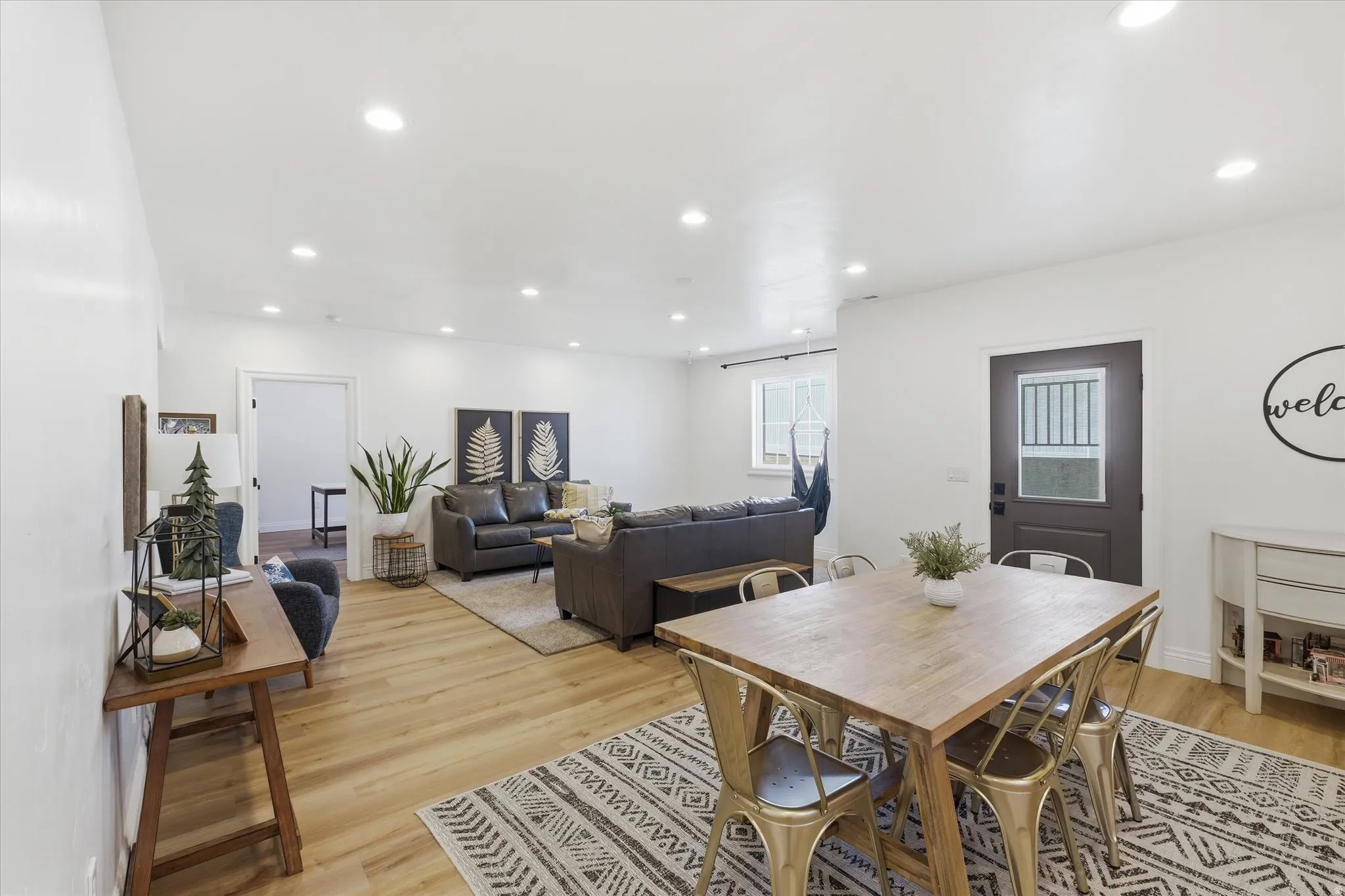 Dining area with light wood finished floors and recessed lighting, outside entrance to basement