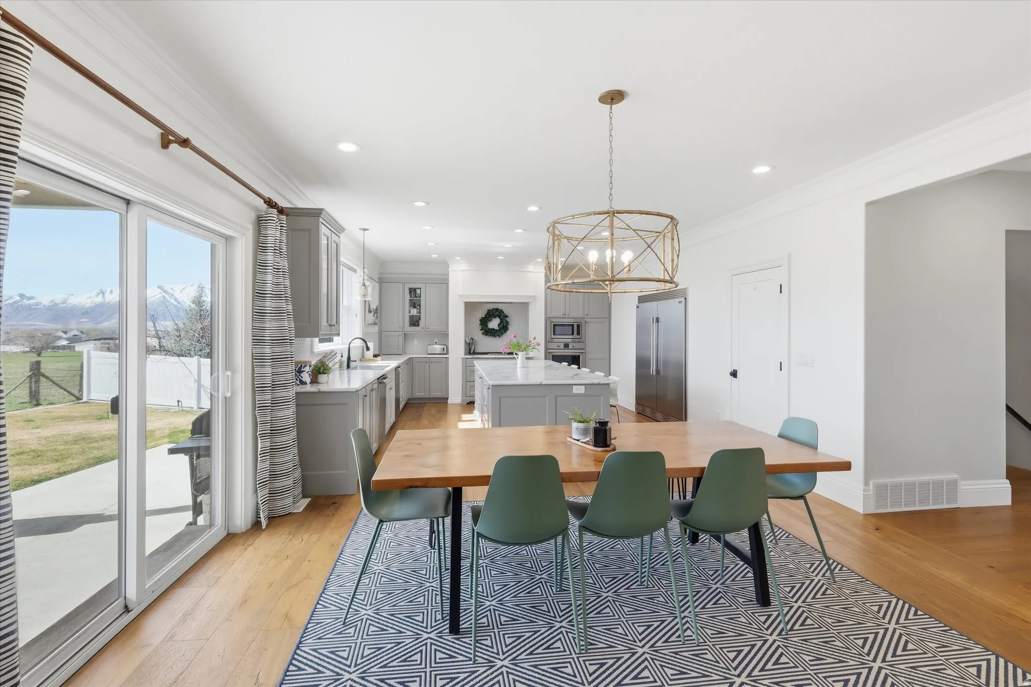Dining area featuring ornamental molding, light wood-type flooring, a chandelier, and a mountain view