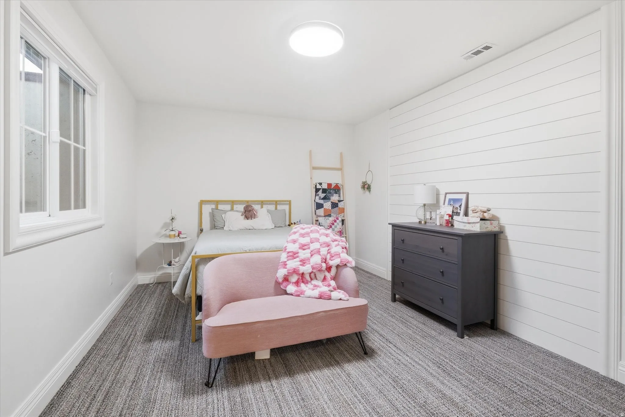 Bedroom with carpet floors, ship lap wall, walk in closet
