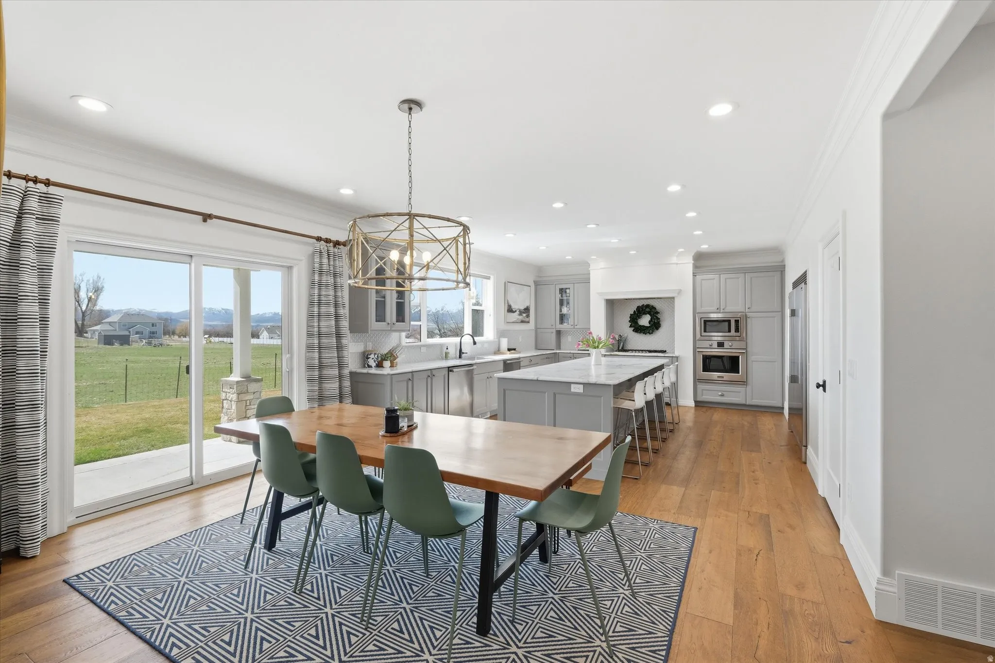 Dining room with crown molding, light wood-type flooring, and a chandelier