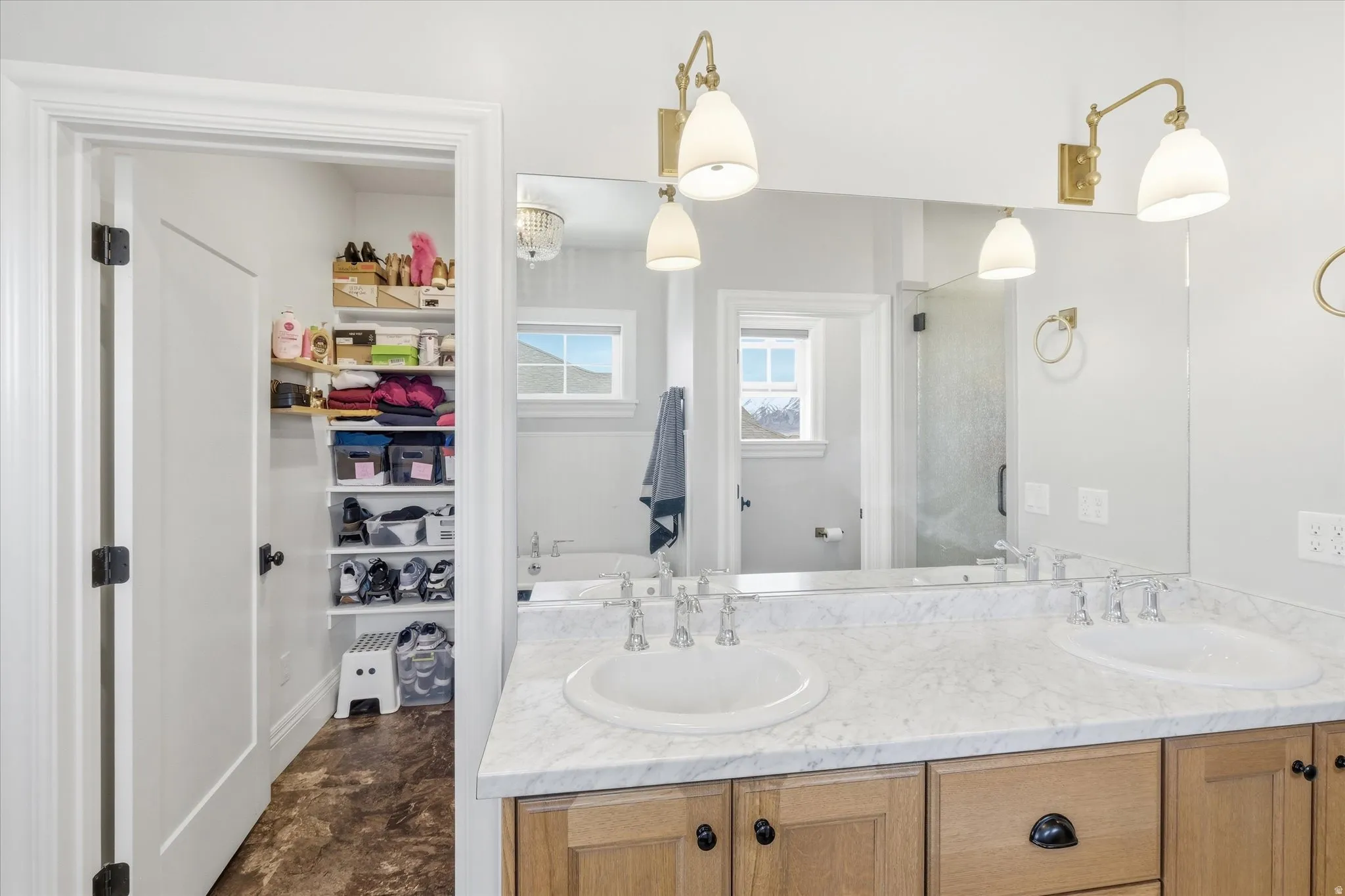 Full bathroom with a walk in closet, double vanity, and a stall shower