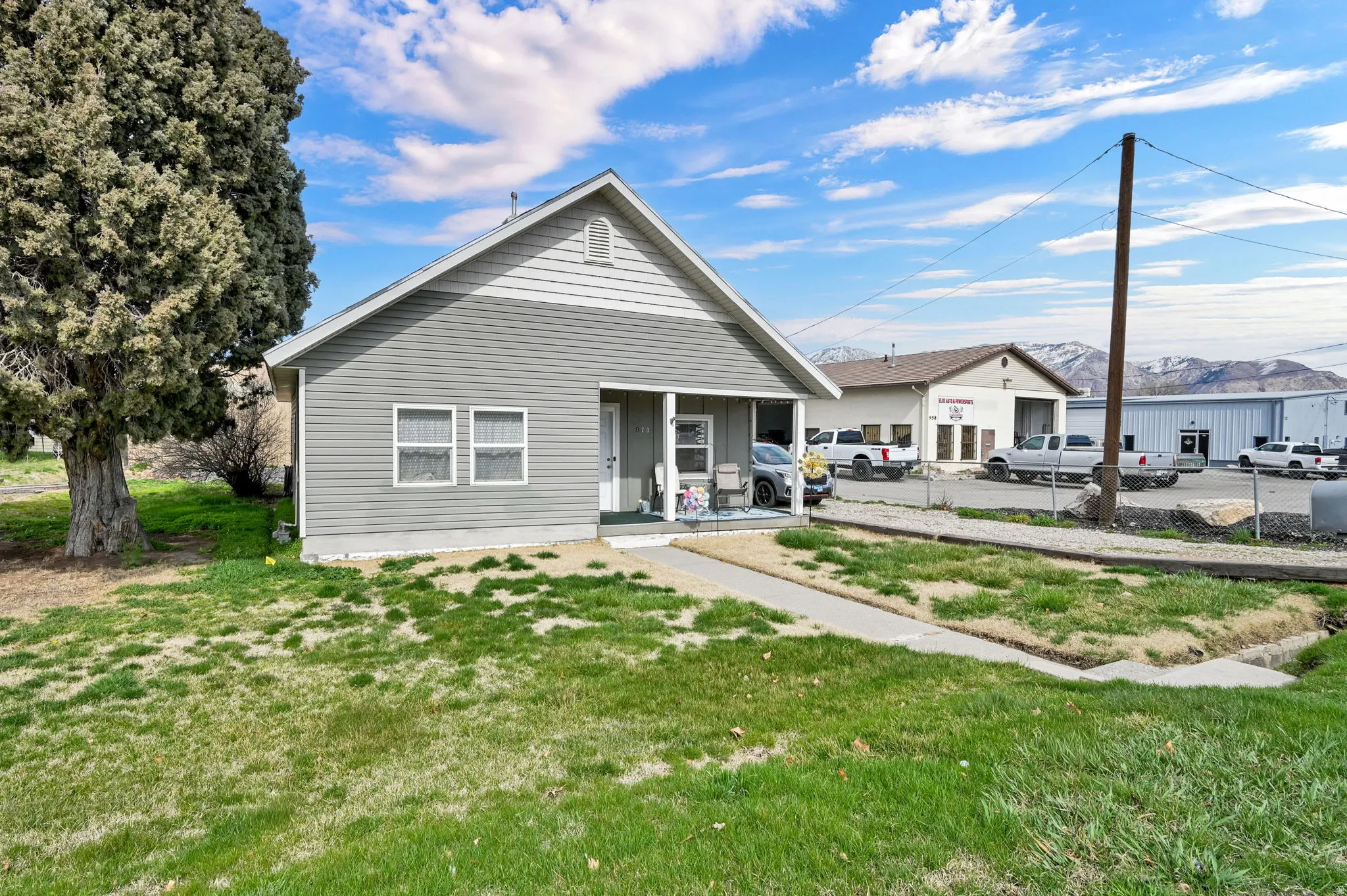 View of front of house featuring covered porch, a front yard, and a mountain view