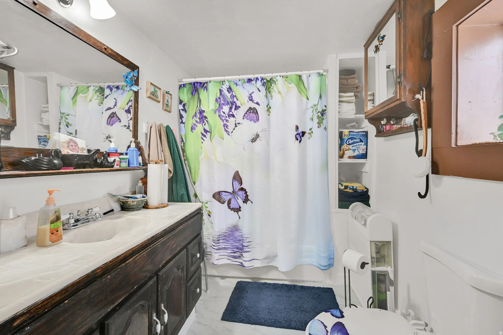 Full bathroom featuring vanity, shower / bath combination with curtain, and light marble finish flooring