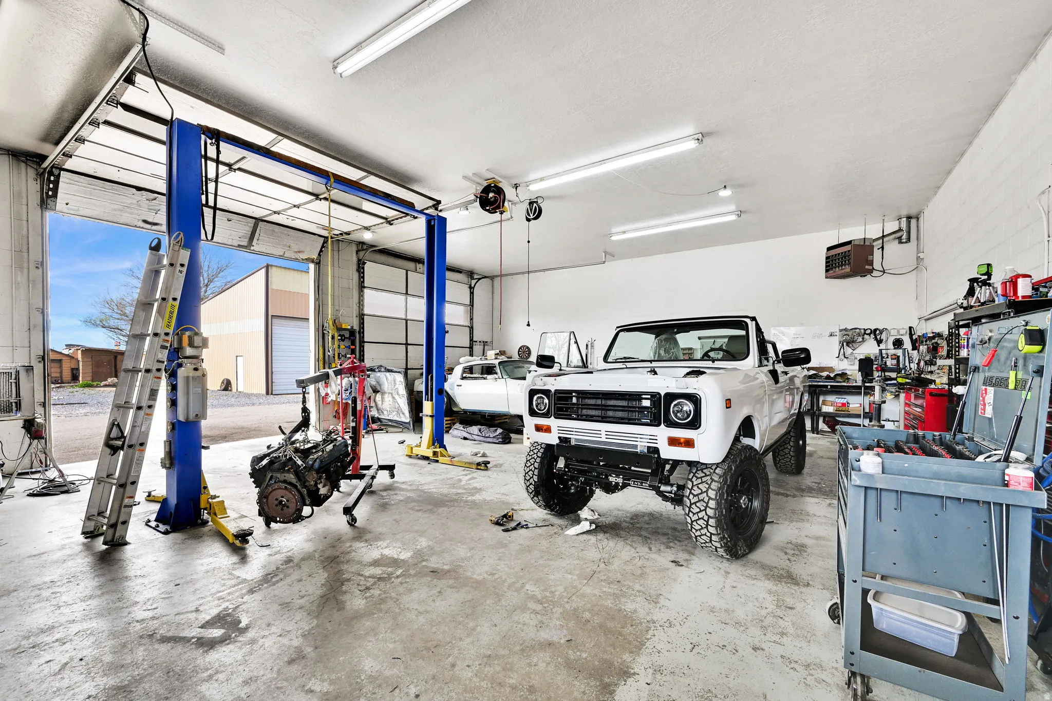 Garage featuring a heating unit and a workshop area