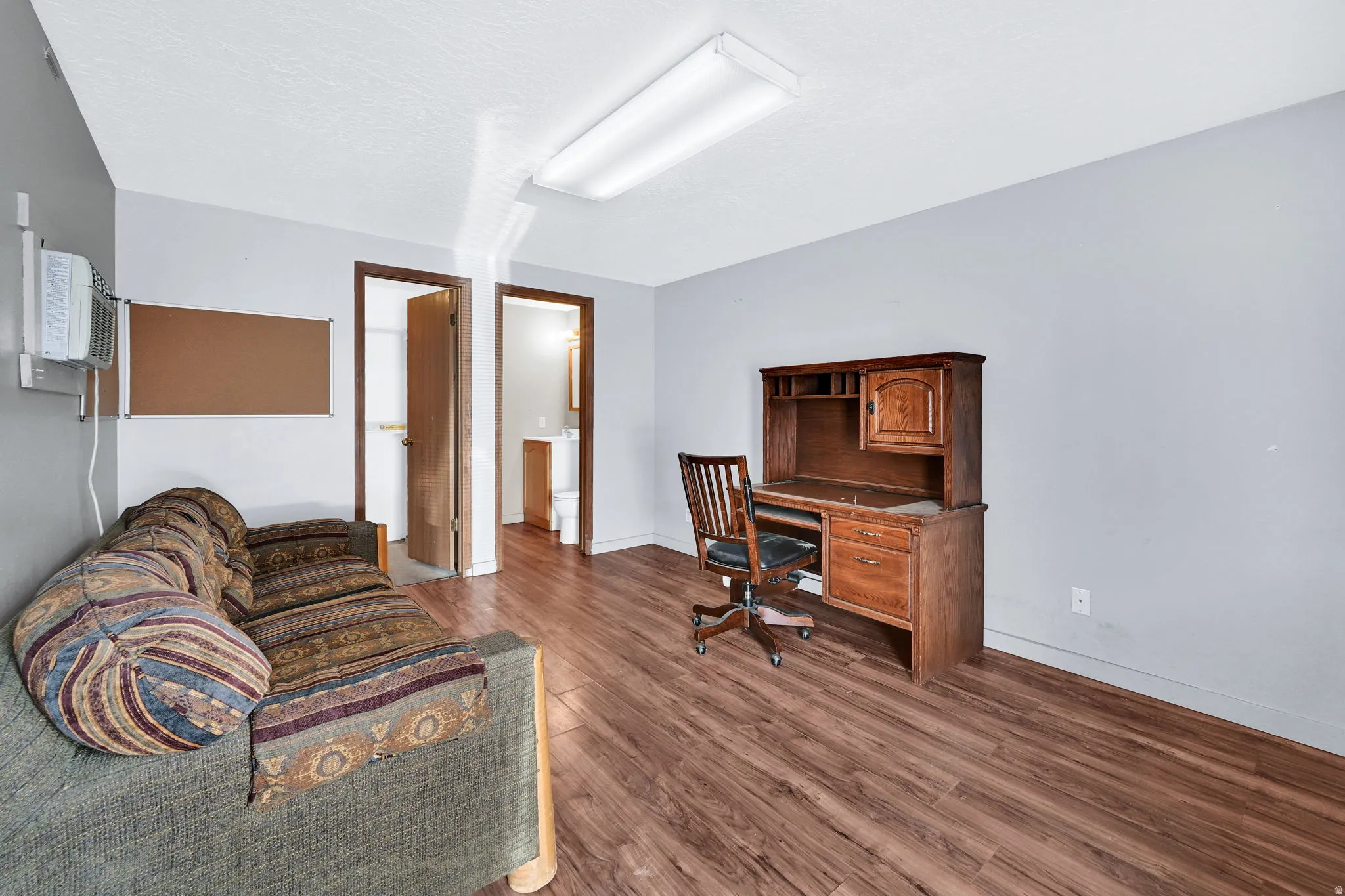 Office space with dark wood-type flooring and baseboards