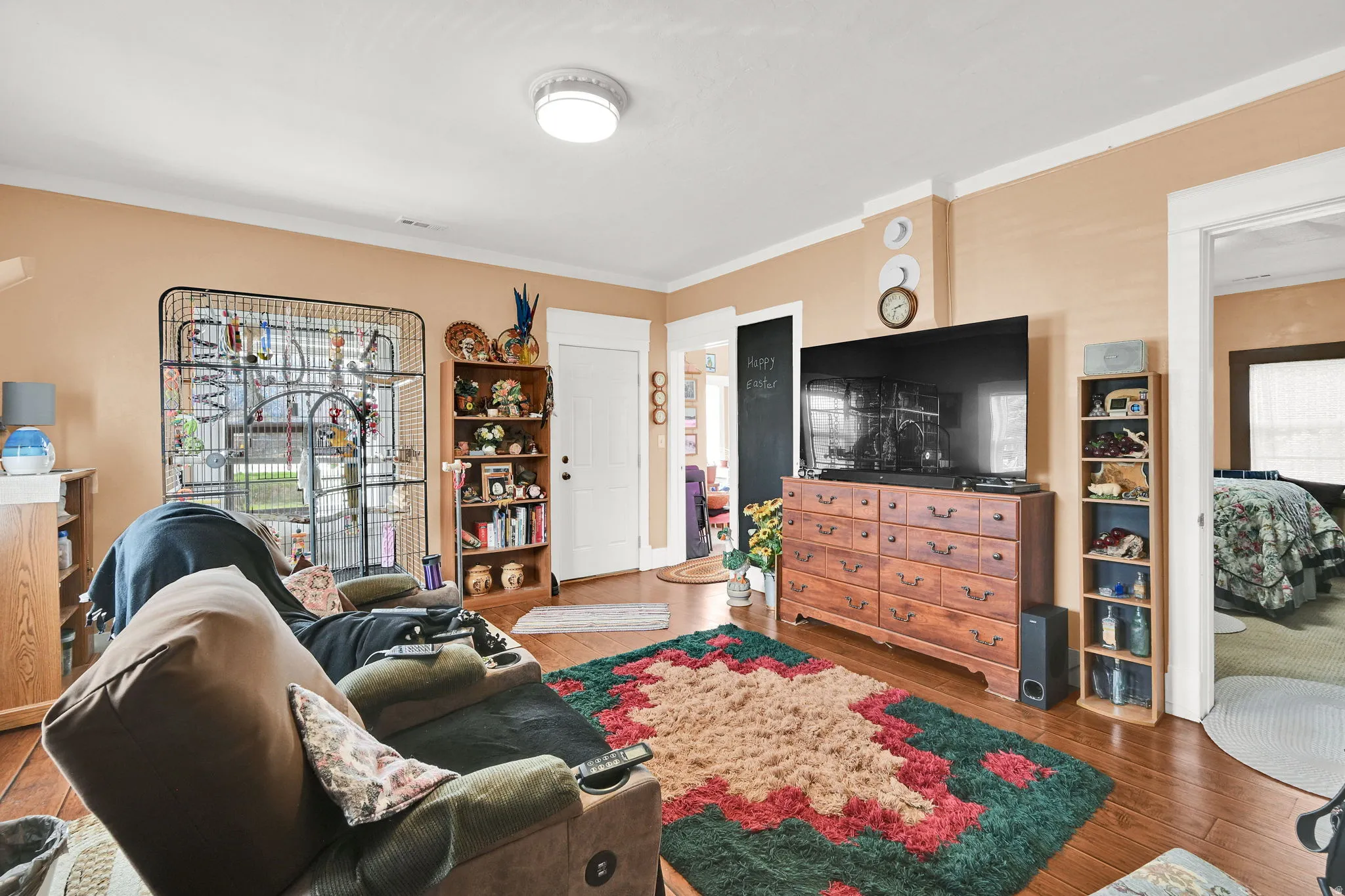Living area with dark wood-style floors and crown molding