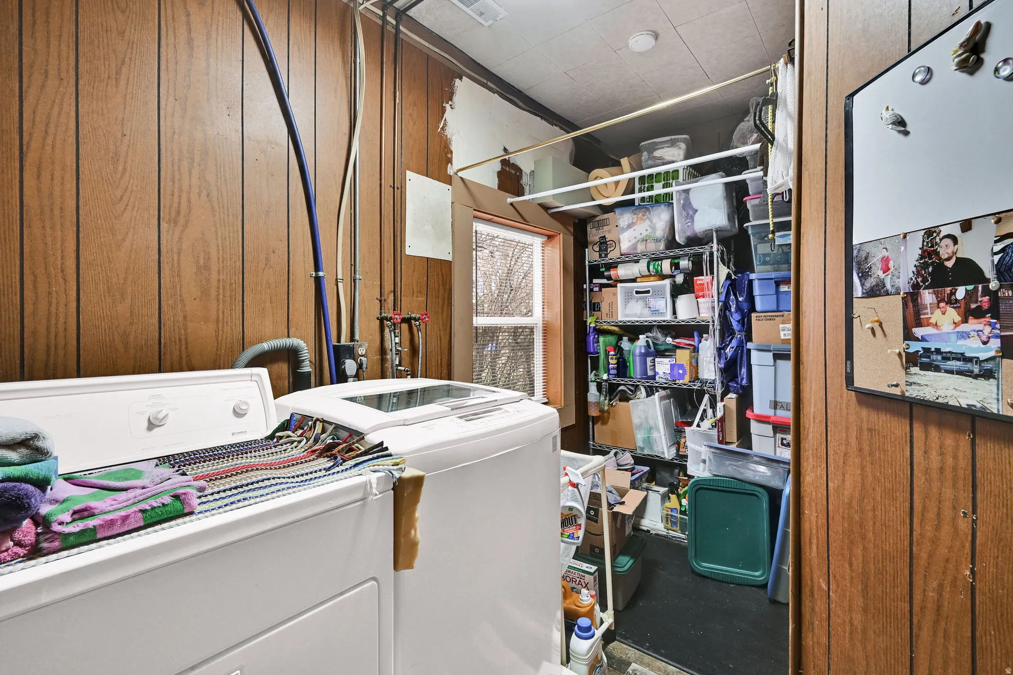 Laundry room featuring wood walls and washer and dryer