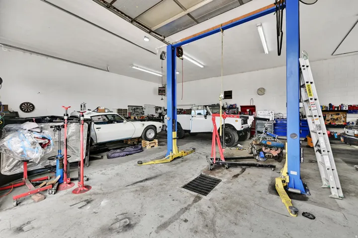 Garage featuring a heating unit and a workshop area