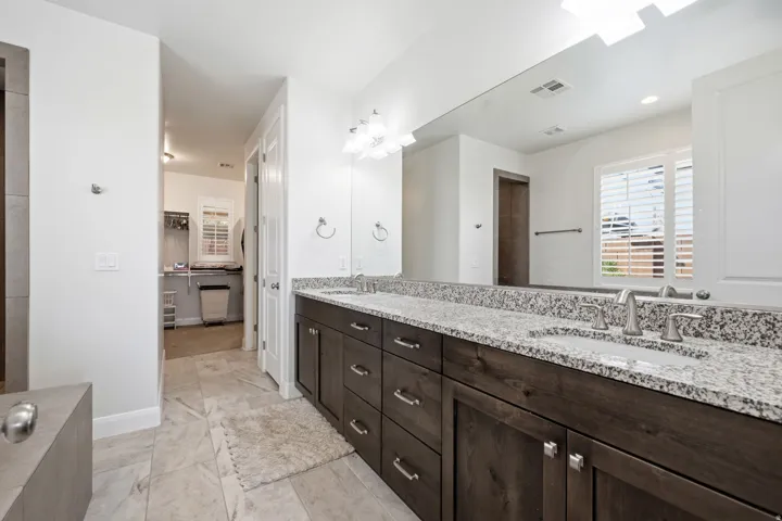 Full bathroom with double vanity and a spacious closet