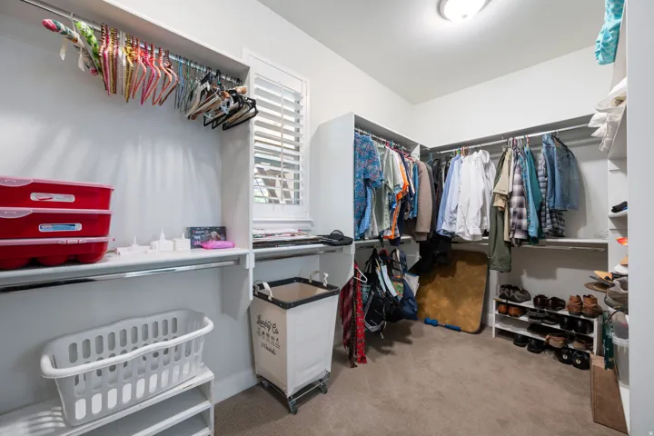 Walk in closet featuring light colored carpet