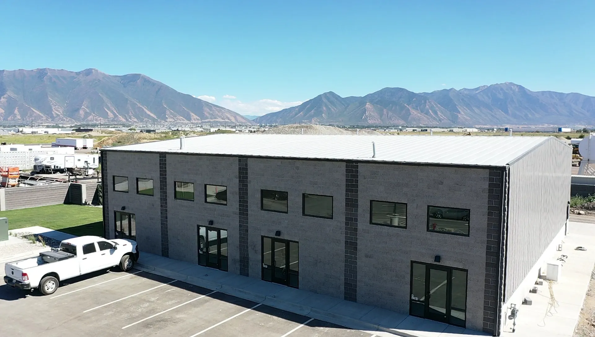 View of building exterior featuring a mountain view and uncovered parking