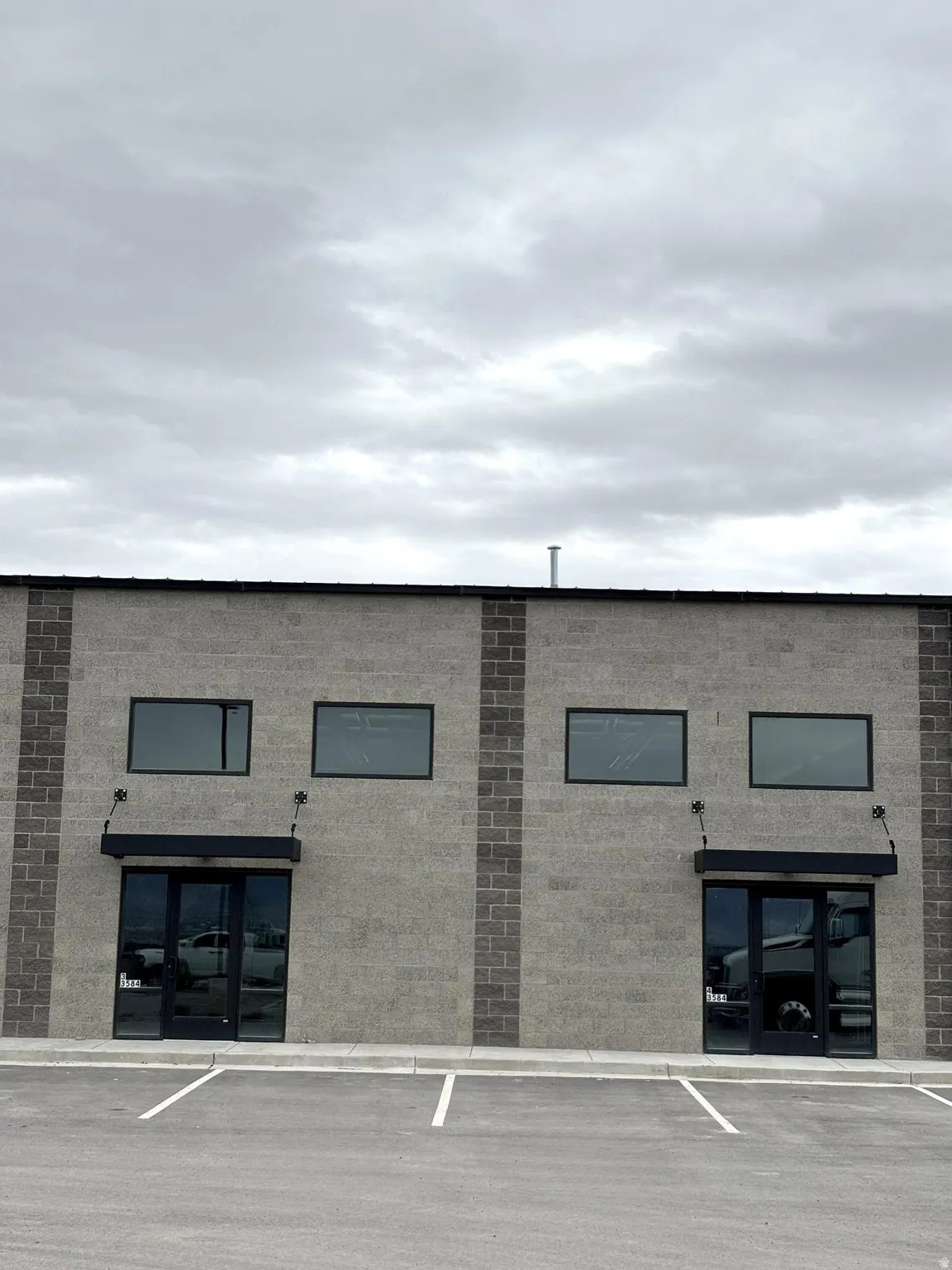 View of building exterior featuring uncovered parking