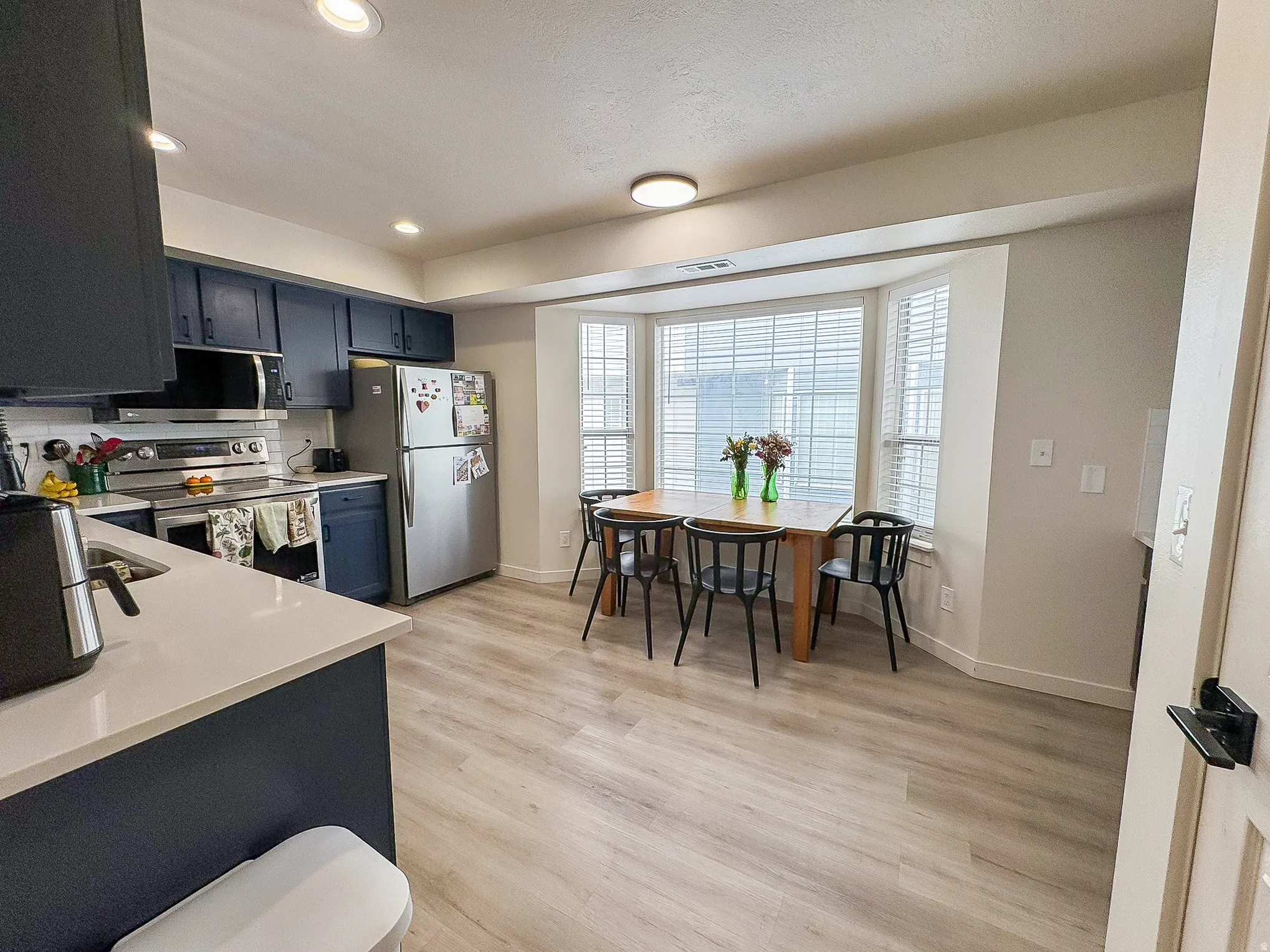 Kitchen with stainless steel appliances, light wood-type flooring, and recessed lighting