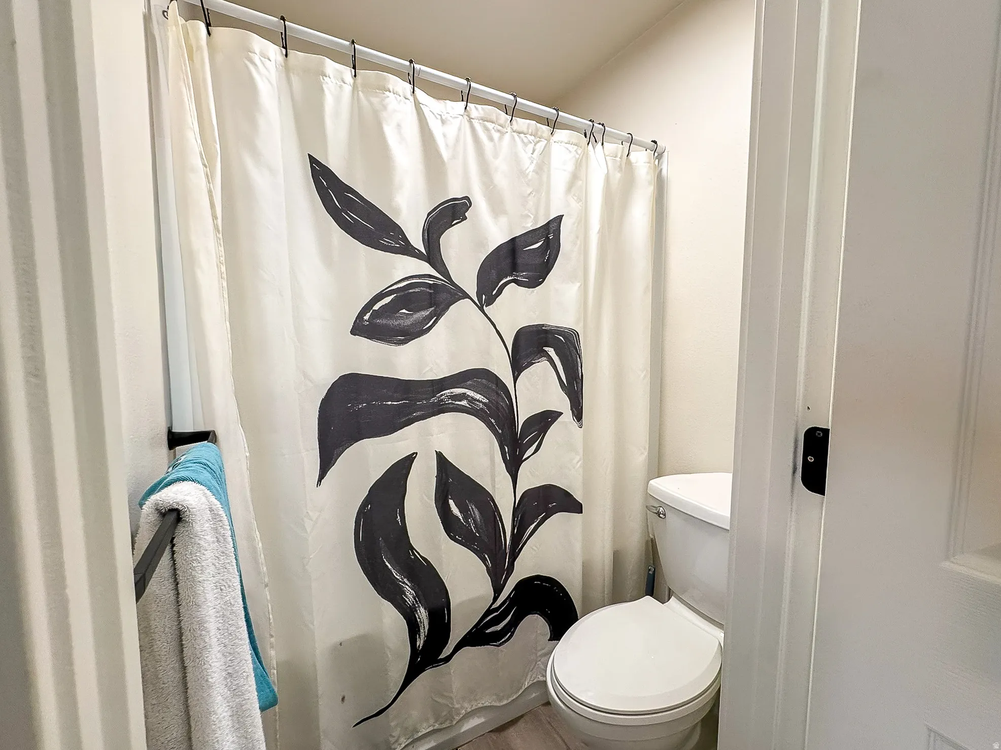 Full bathroom with a shower with shower curtain and toilet