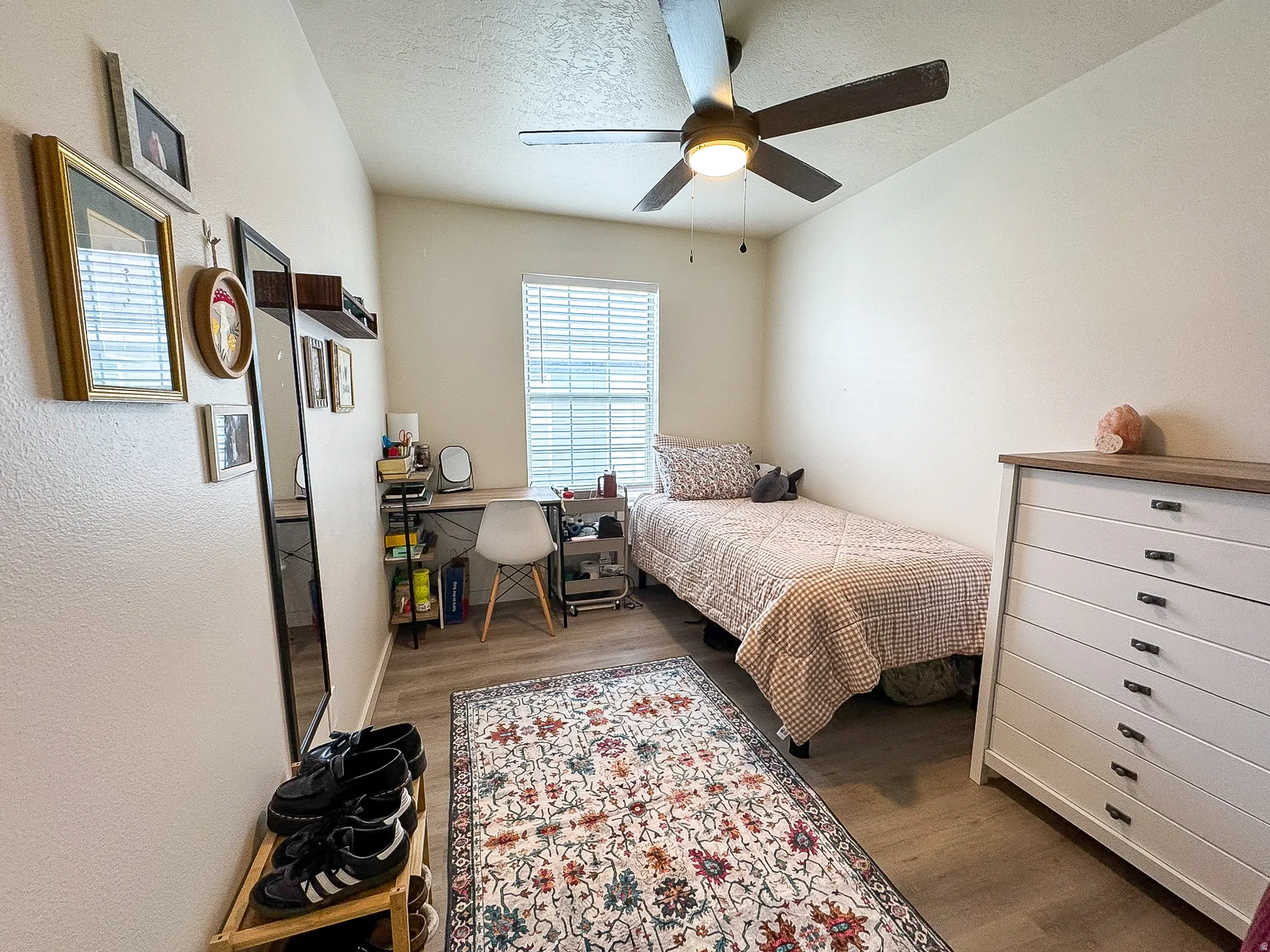 Bedroom featuring a textured ceiling, dark wood-style flooring, ceiling fan, and an office area
