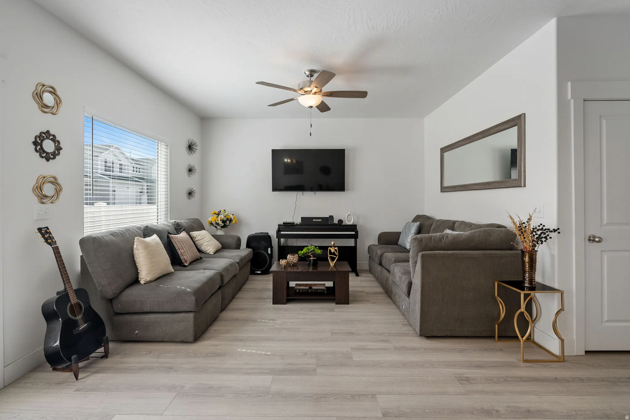 Living room with a ceiling fan and light wood finished floors