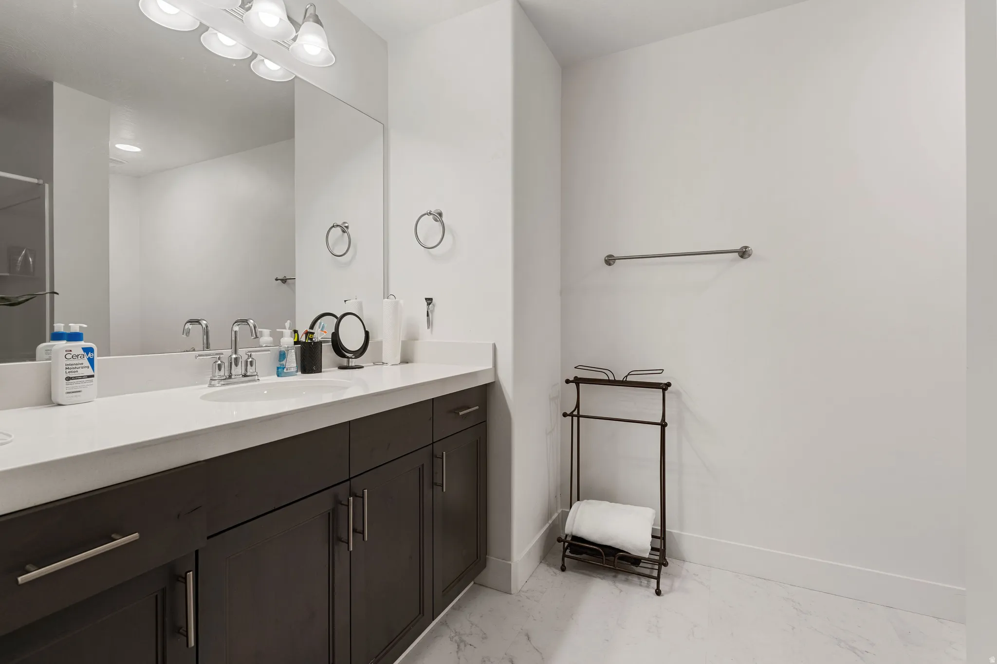 Full bathroom with vanity and light marble finish floors