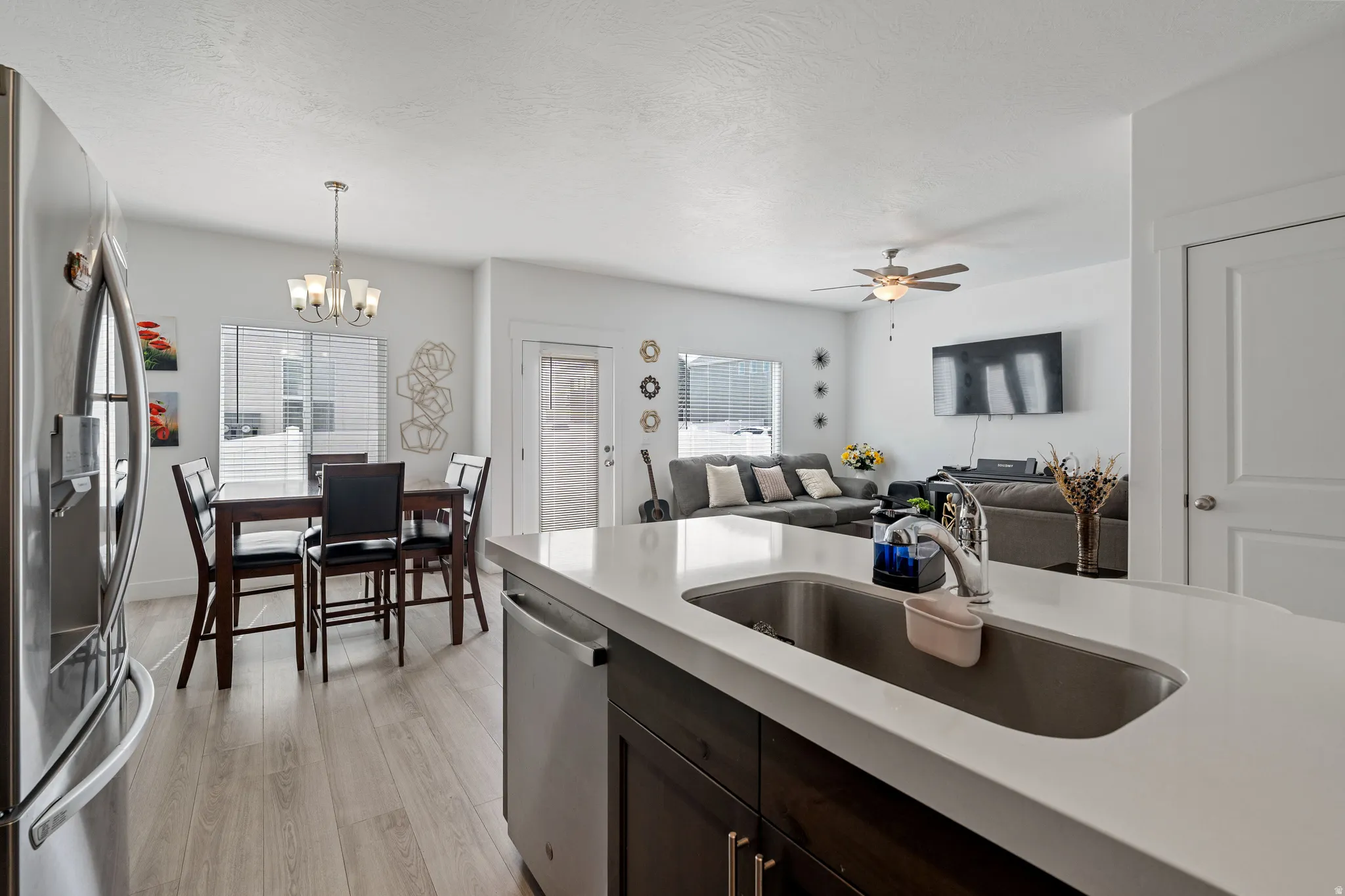 Kitchen featuring open floor plan, stainless steel appliances, light wood-style floors, and healthy amount of natural light