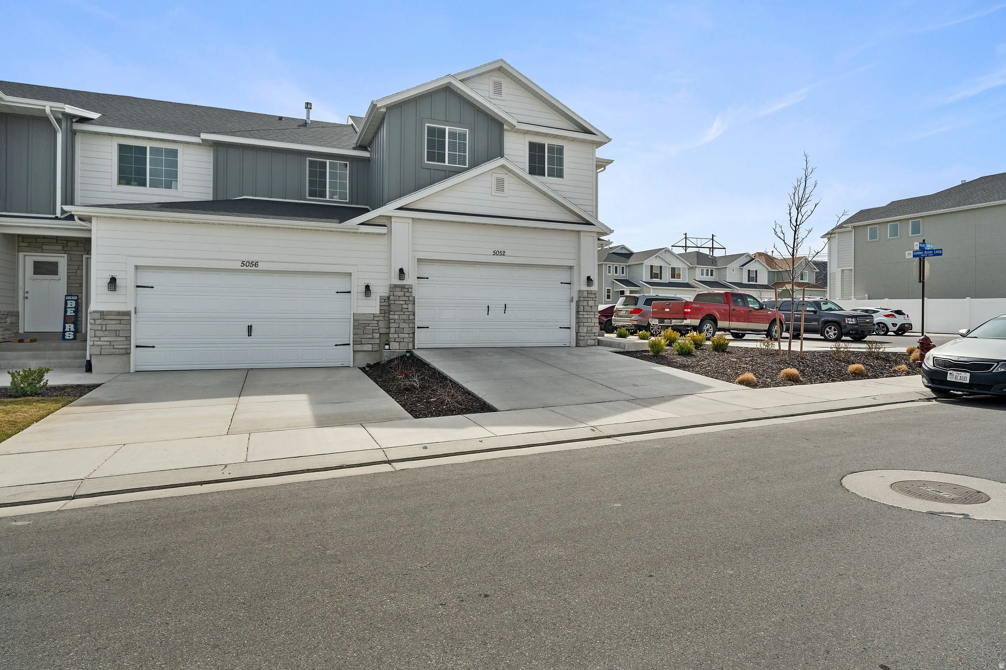 View of front of property with board and batten siding, stone siding, concrete driveway, a residential view, and a garage