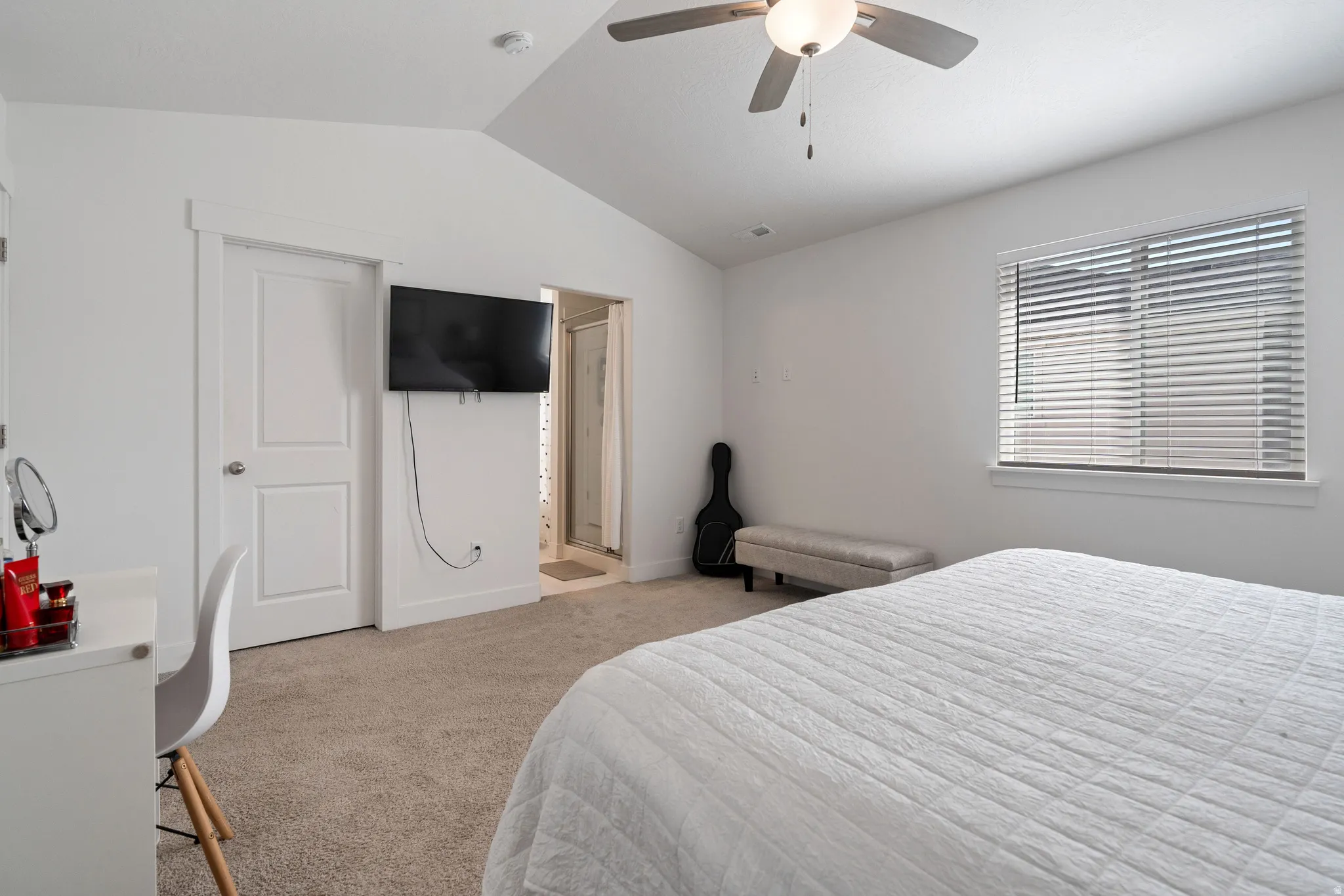 Bedroom featuring connected bathroom, light colored carpet, and ceiling fan