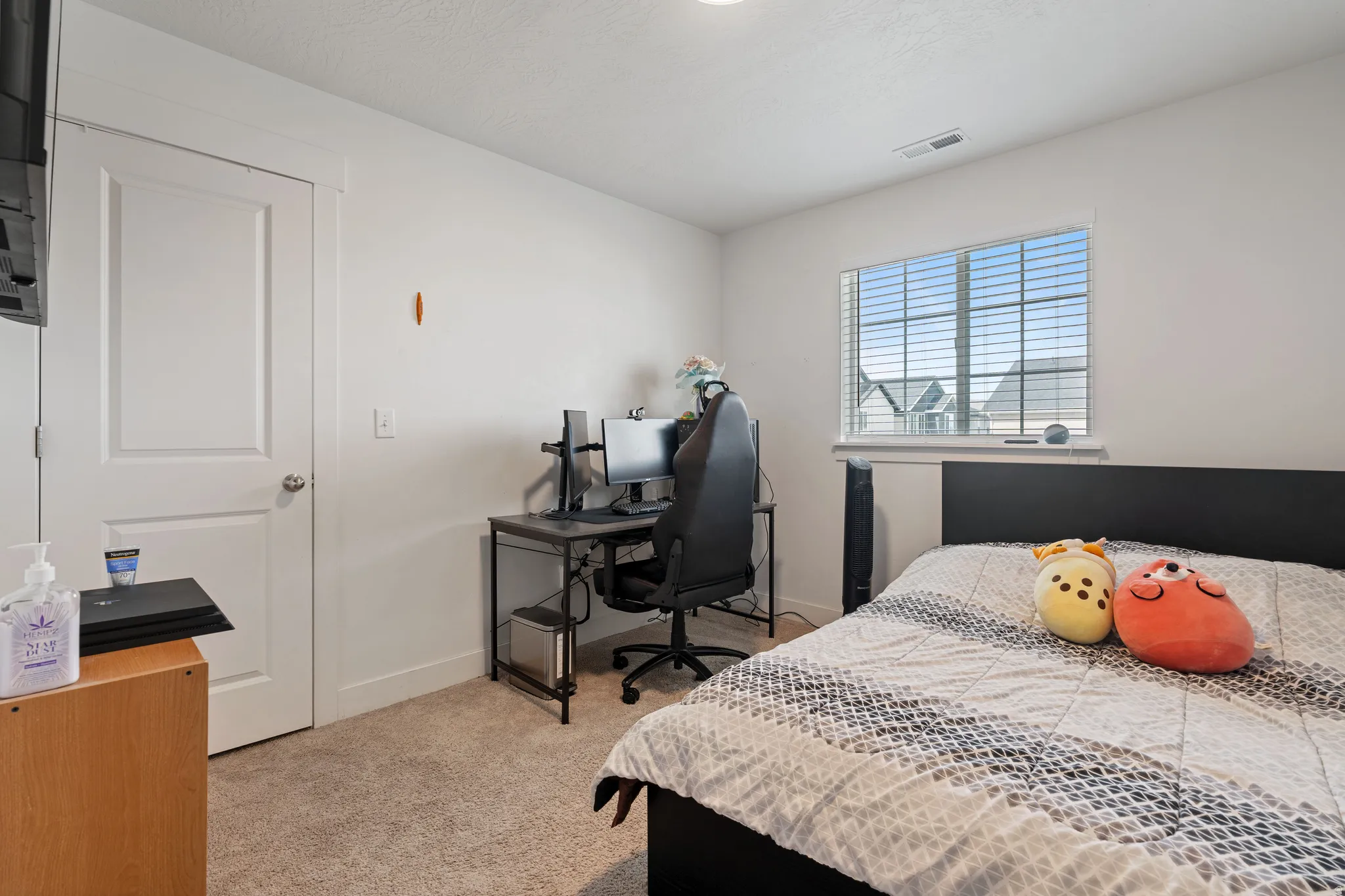 Bedroom featuring light carpet and an office area