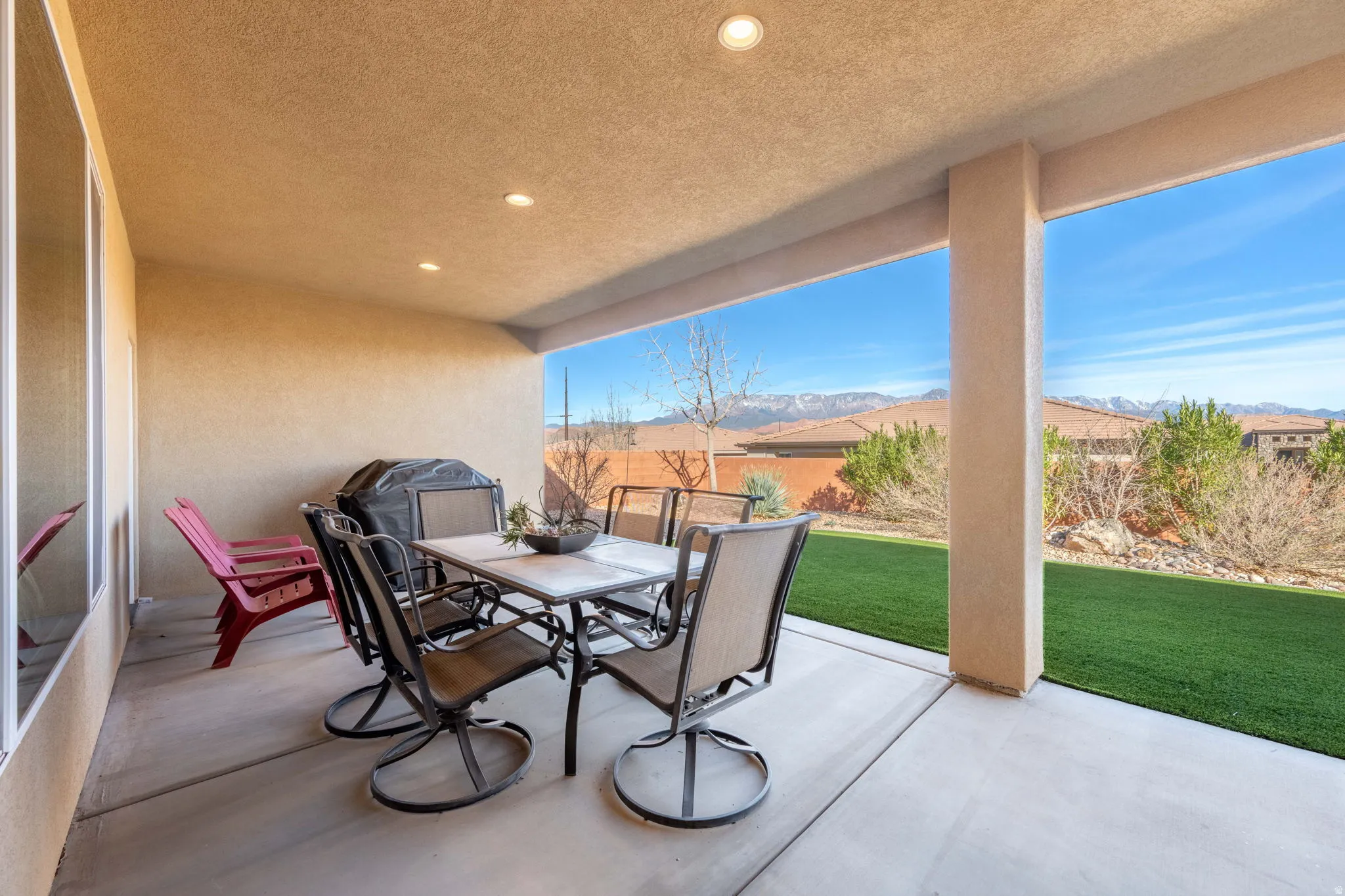 Fenced backyard featuring outdoor dining space, a patio, a mountain view, and grilling area
