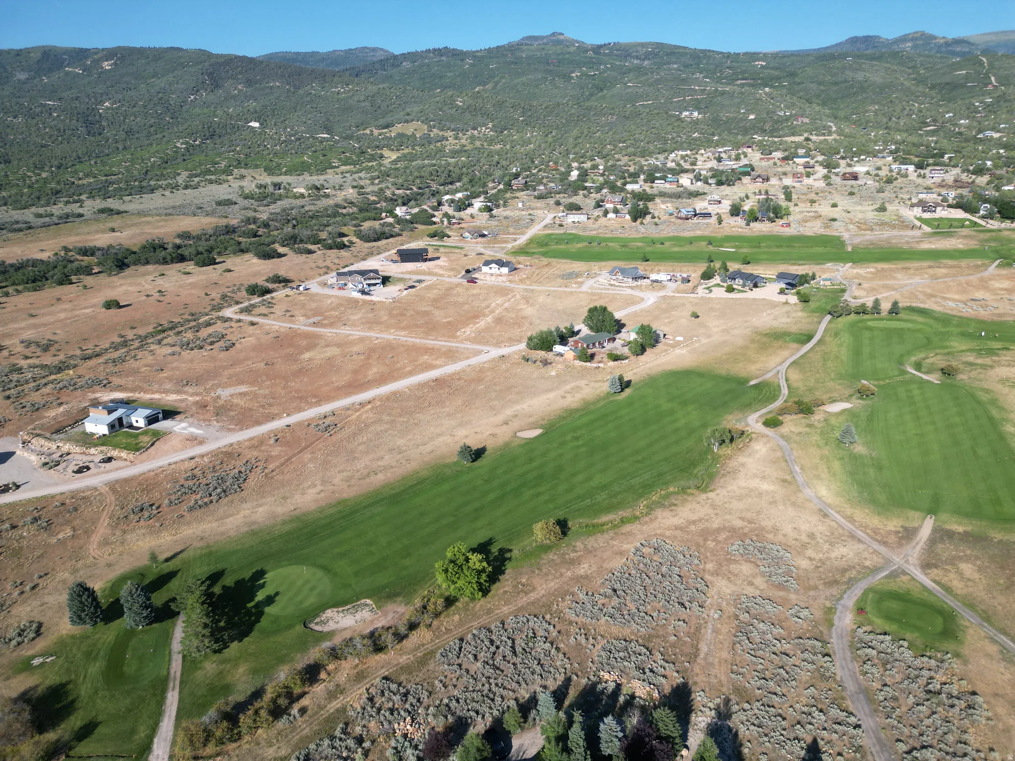 View of property location featuring a mountainous background and a golf course