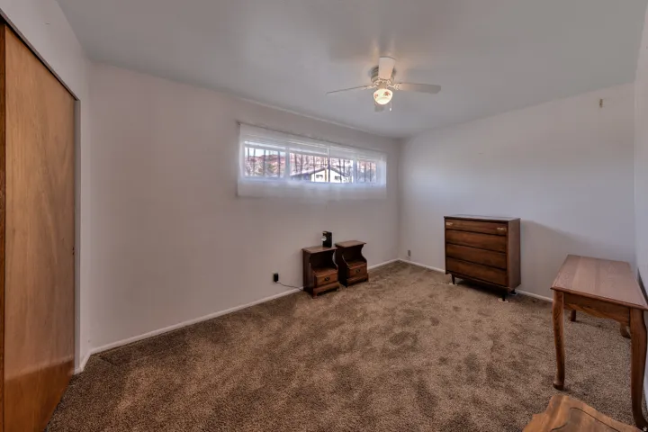Unfurnished bedroom featuring a closet, carpet floors, and ceiling fan