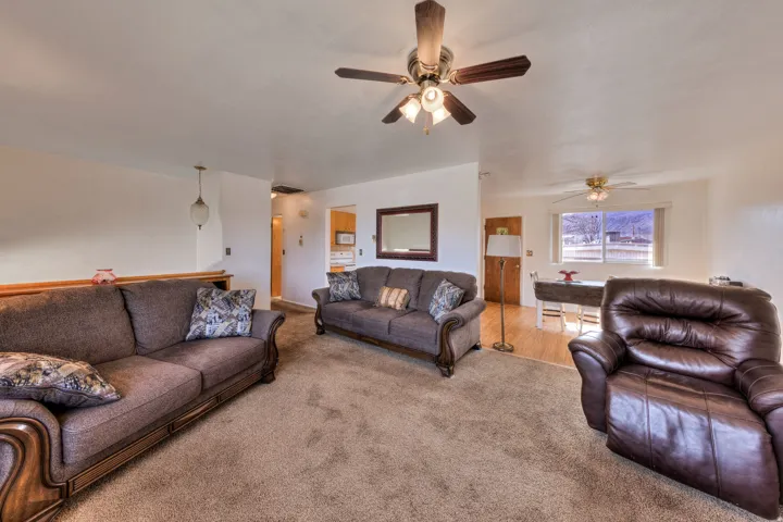 Living area with carpet floors and ceiling fan
