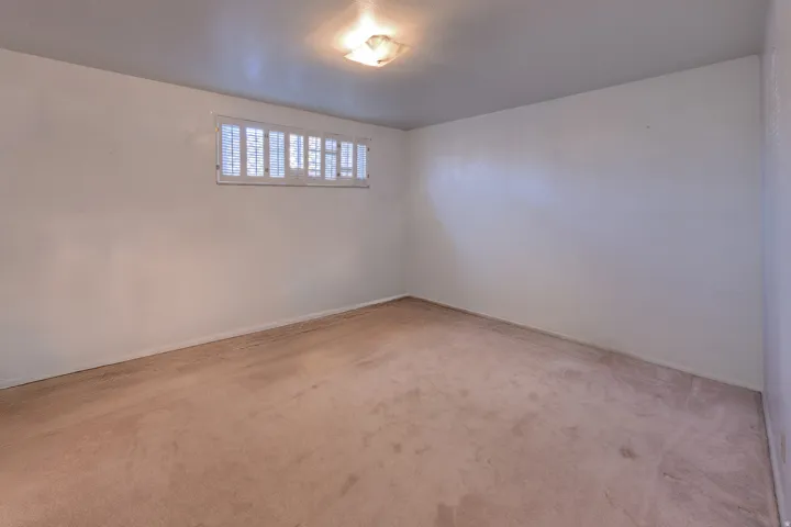 Unfurnished room with light carpet and baseboards