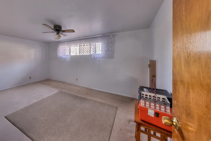 Empty room with carpet and a ceiling fan