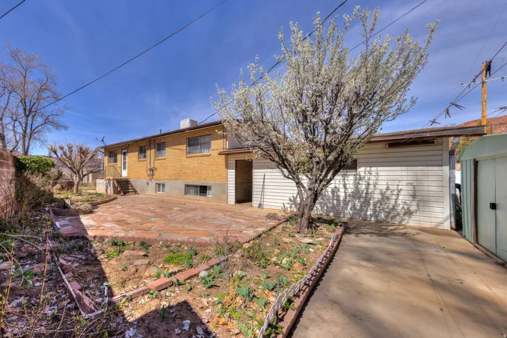 Back of property featuring a patio, a chimney, and brick siding