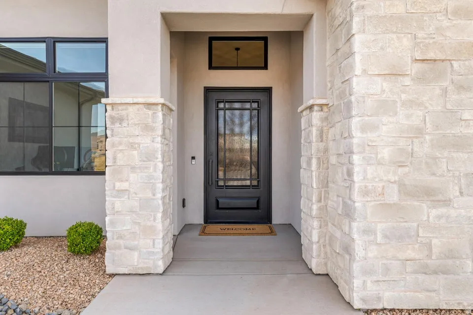 Entrance to property featuring stucco siding and stone siding