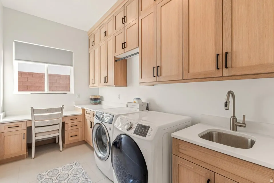 Laundry room with separate washer and dryer, cabinet space, and a desk